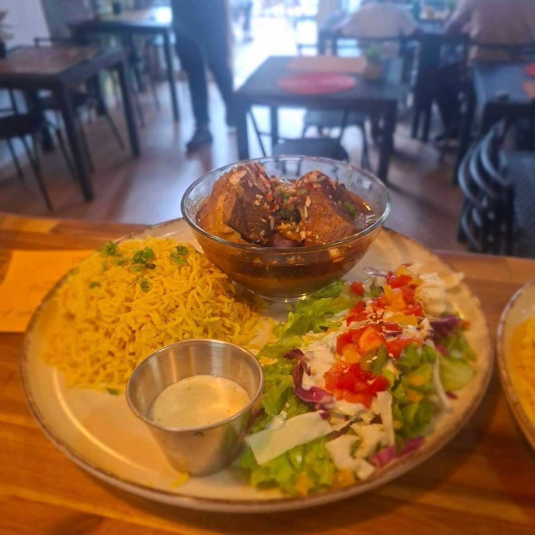 Assiette de viande en sauce, riz et salade dans la salle du restaurant